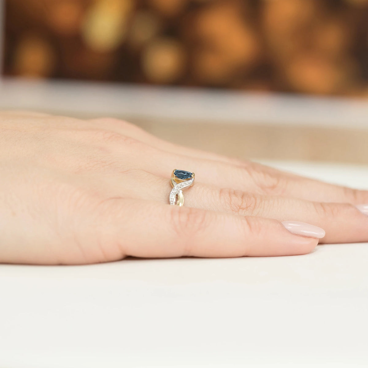 Prsten nekonečna ze žlutého 14k zlata s oválným topazem London Blue 0,50 ct a diamanty 0,05 ct