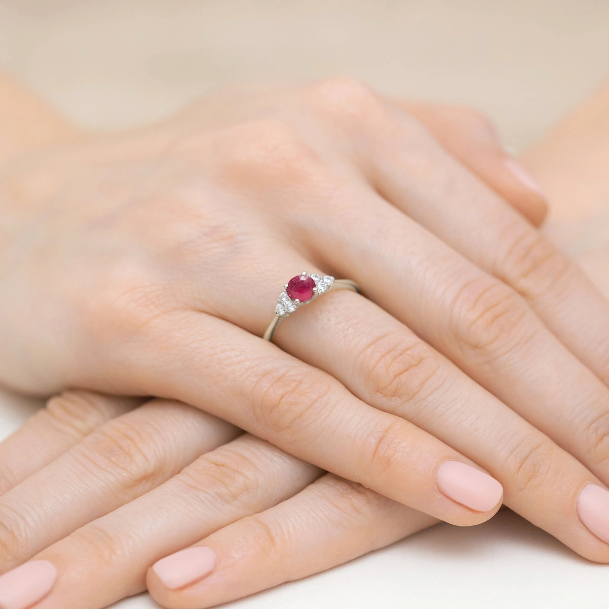 Prsten z bílého 14k zlata s kulatým rubínem 0,60 ct a postranními shluky diamantů 0,18 ct