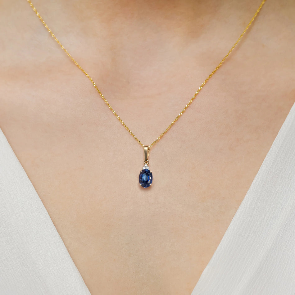Pendant made of the 14K (585) gold. Our offer includes chains, pendants, necklaces. Central oval cut sapphire 0.90ct and 3 diamonds 0.026ct. Perfect unique gift